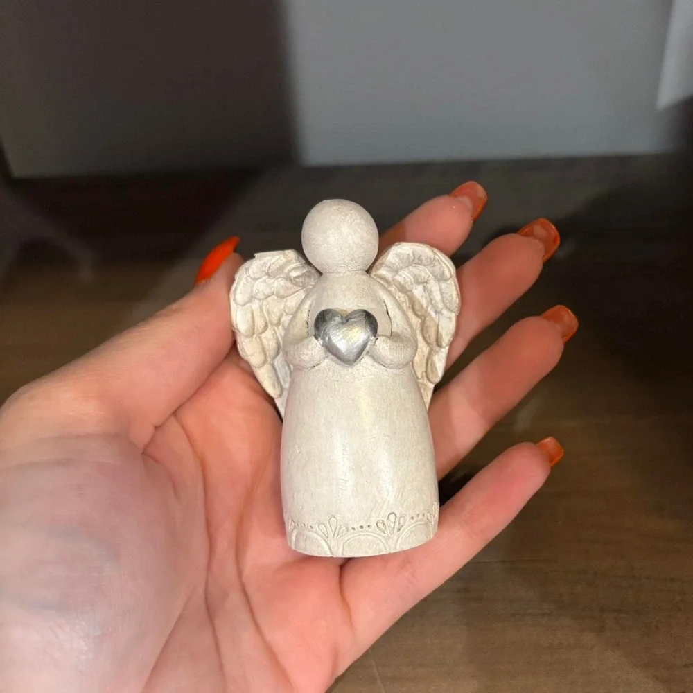 White angel figurine with silver heart